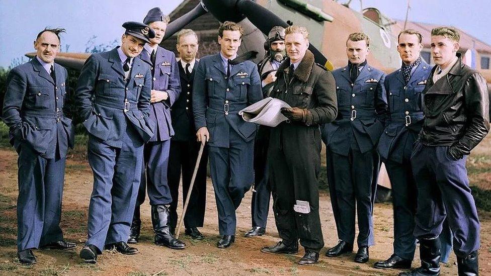 10 pilots posing next to a Hurricane plane