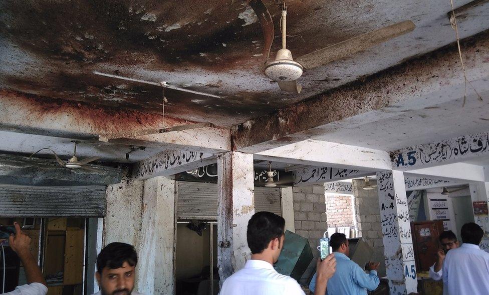 Pakistani local residents inspect the site of a suicide bomb attack at a district court in Mardan on September 2, 2016