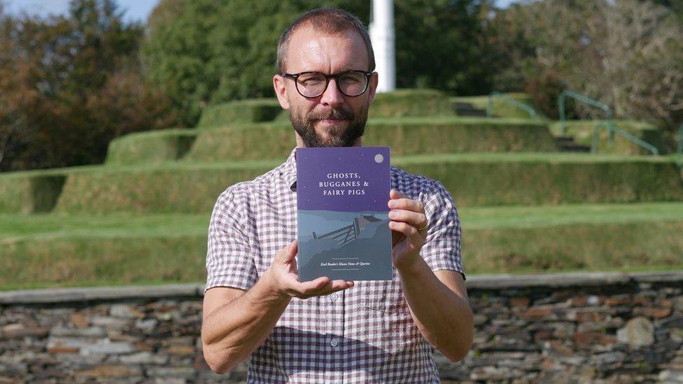 James Franklin holding a copy of the book