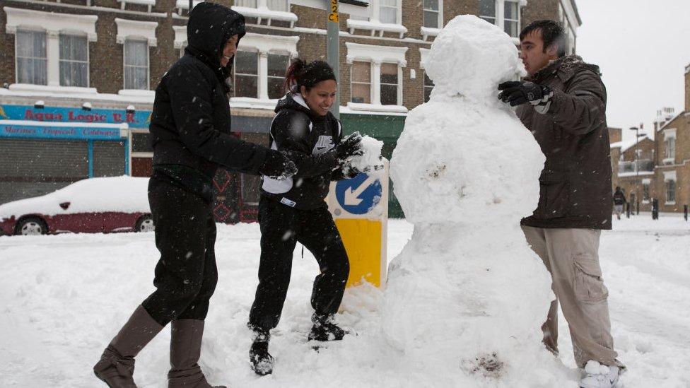 People building a snowman in London in 2009