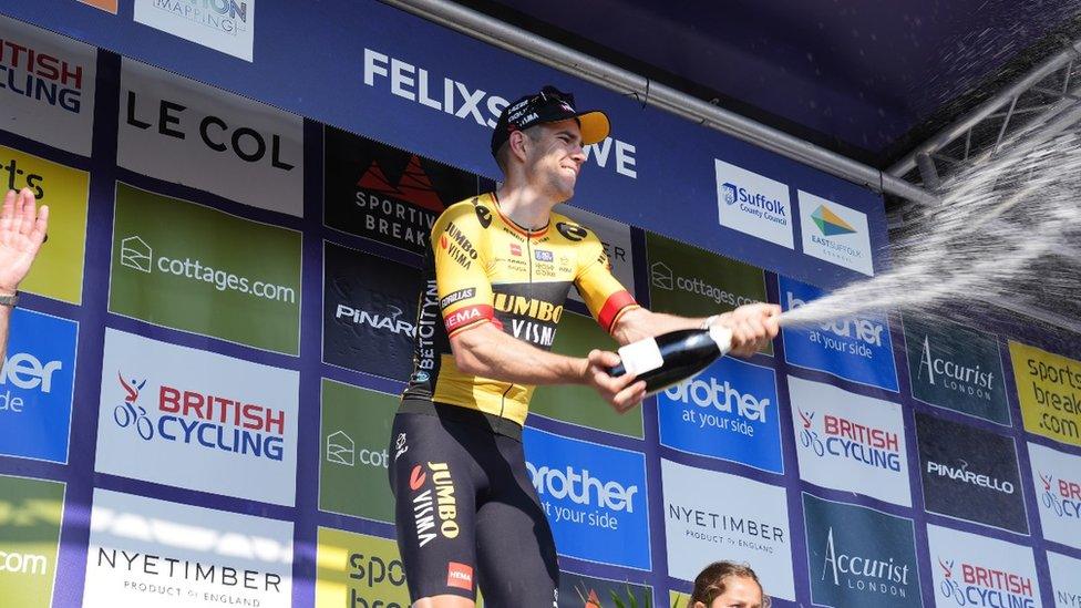 Wout van Aert spraying champagne on stage