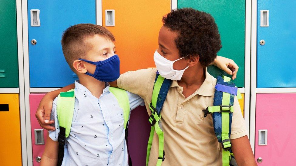 Two school children by colourful lockers