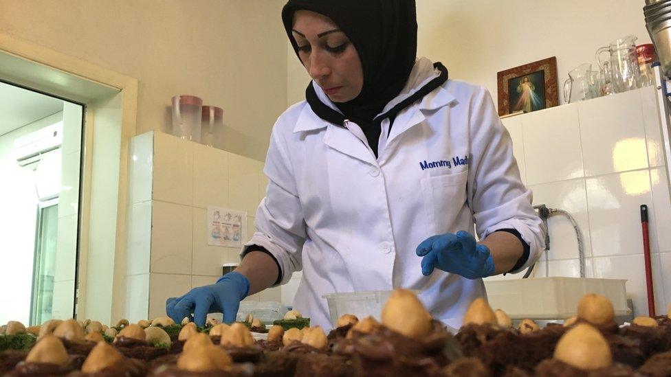 Woman with lots of cakes in front of her