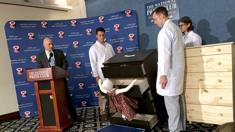 Elliot Kaye (L), chair of the Consumer Product Safety Commission (CPSC) and CPSC employees watch as a 28-pound (13 kilo) dummy(C) falls over and under IKEAs Malm model chest of drawers, during a live demonstration at the National Press Club in Washington, DC 28 June, 2016.