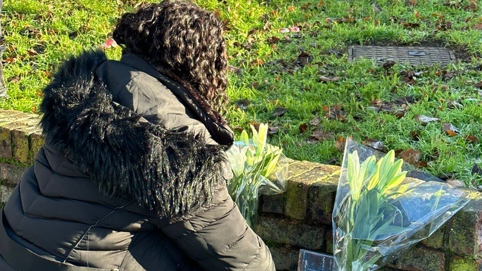 Woman leaving flowers near the scene of the killing