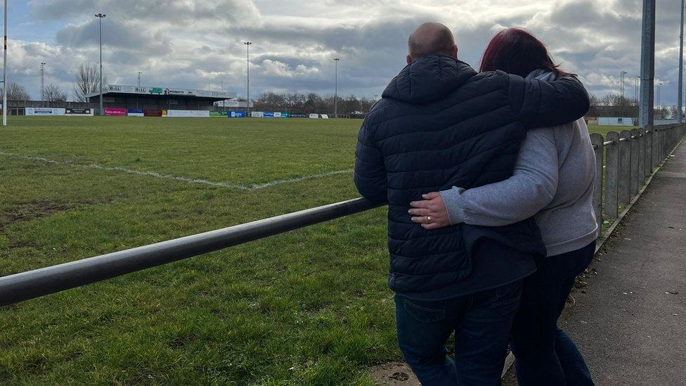 Ben and Amy Branson embracing each on the rugby club field