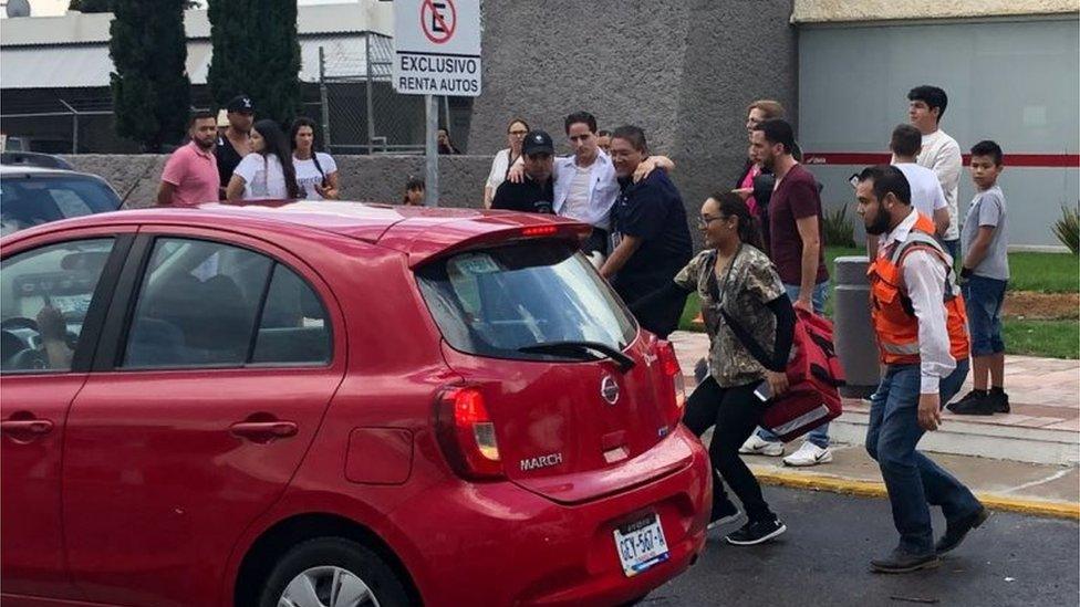 Picture released by Contacto Hoy showing a man (C) being rushed into a vehicle at the airport of Durango, in northern Mexico, after a plane carrying 97 passengers and four crew crashed on take off near the city's airport on July 31, 2018.