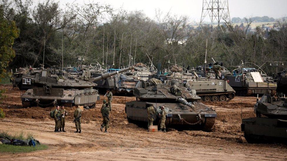 Israeli soldiers stand next to tanks and armoured personnel carriers near the border with Gaza (26 March 2019)