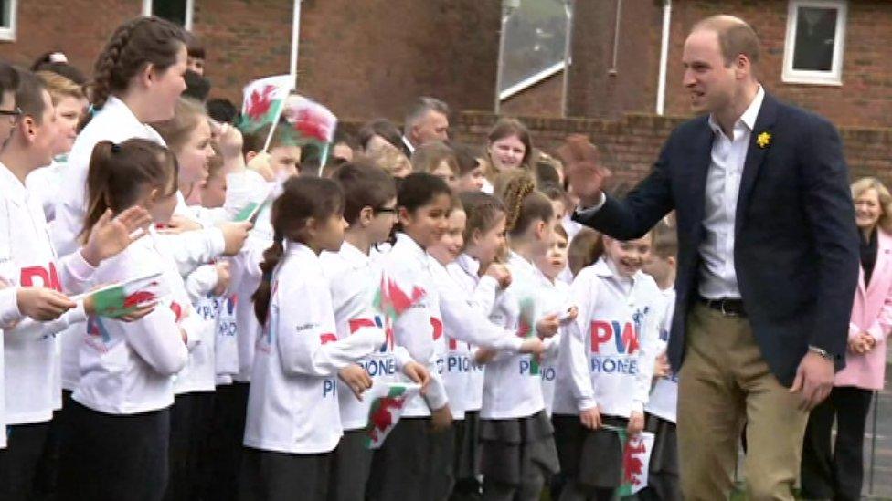 Prince William speaks to schoolchildren as he arrives at the school in Abergavenny