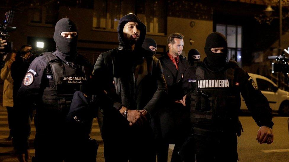 Andrew Tate and Tristan Tate are escorted by police officers outside the headquarters of the Directorate for Investigating Organized Crime and Terrorism in Bucharest (DIICOT)