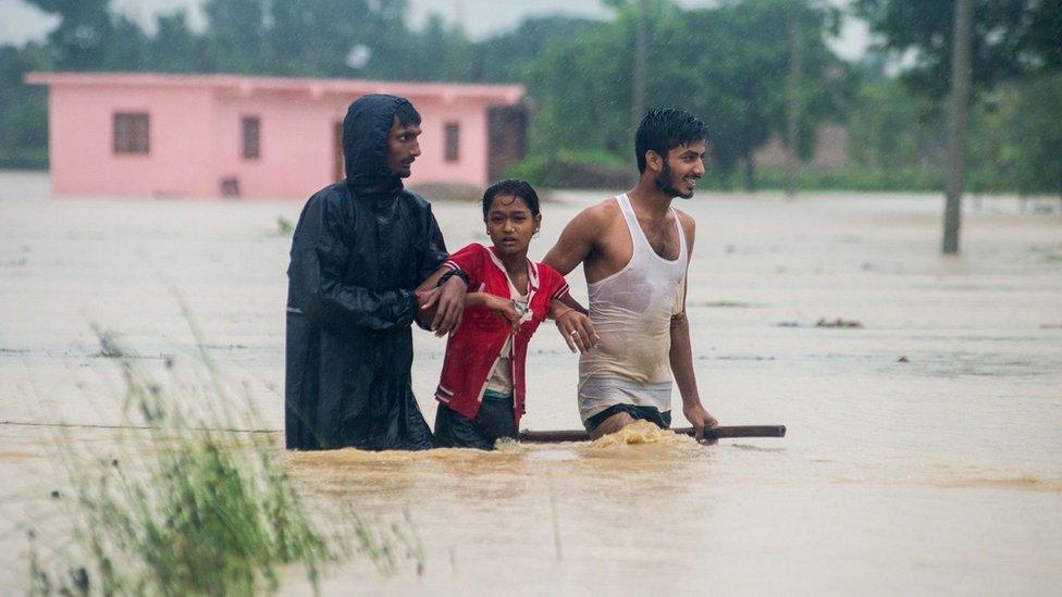 Nepali residents wade along a flood area at Birgunj Parsa district, some 200km south of Kathmandu,