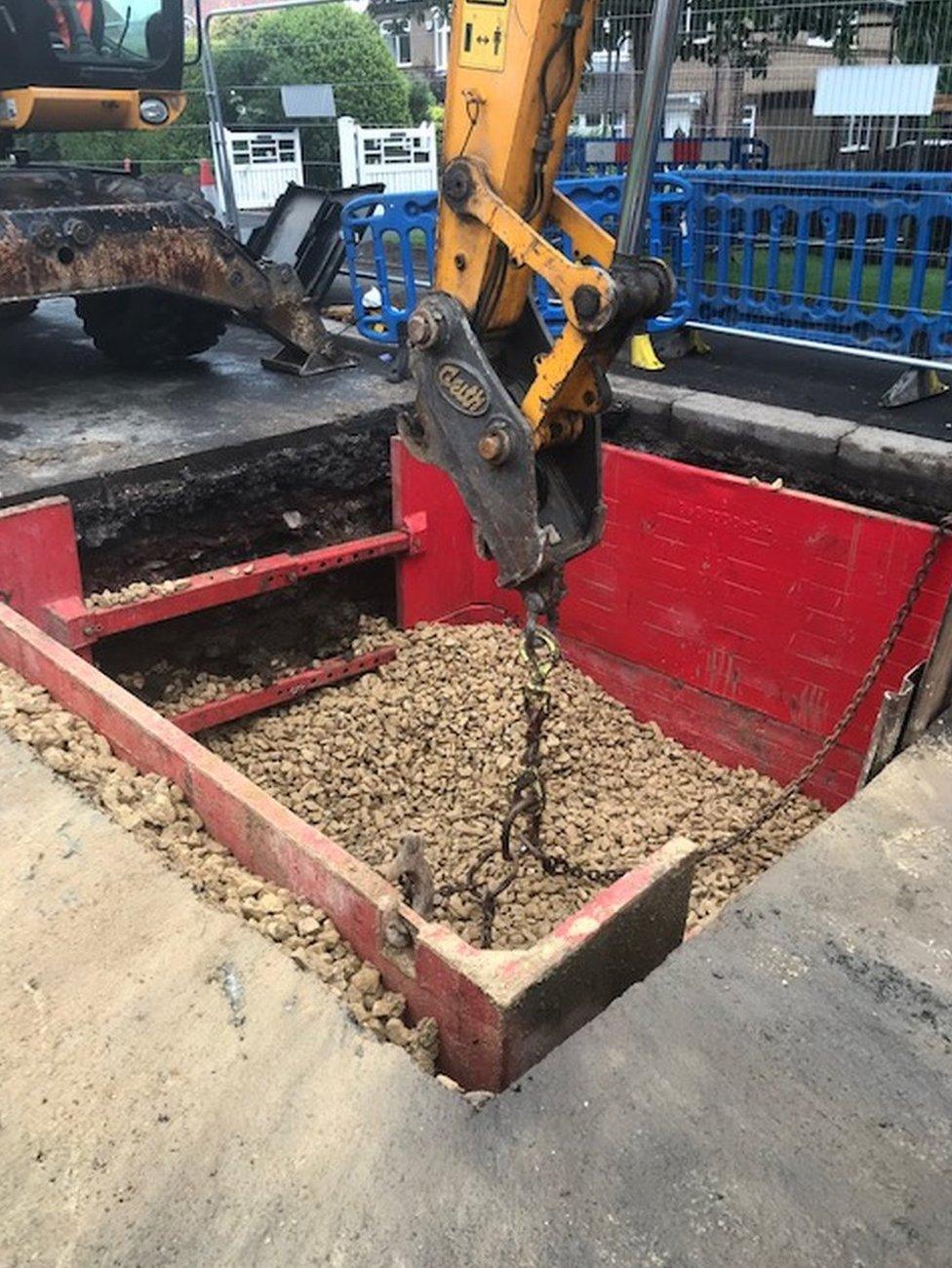 A digger helps fill in the void on Seaton Lane