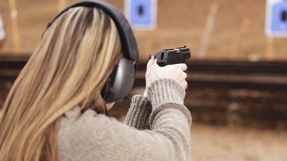 A woman firing a gun