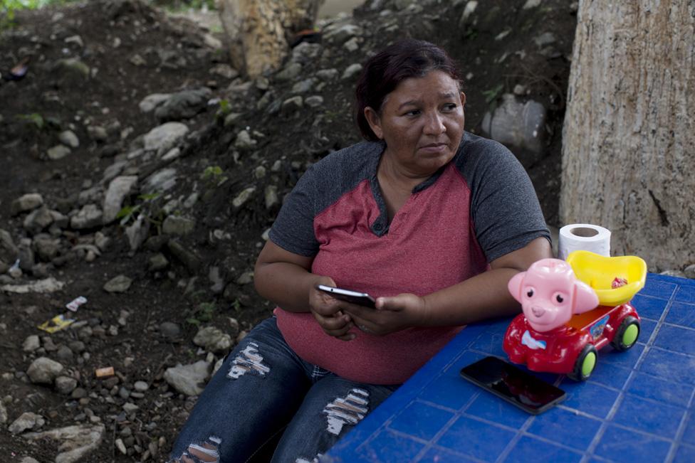 Sandra Pérez Maldonado sits at a table outside her mother's home