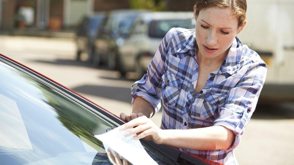 Woman looks at parking notice