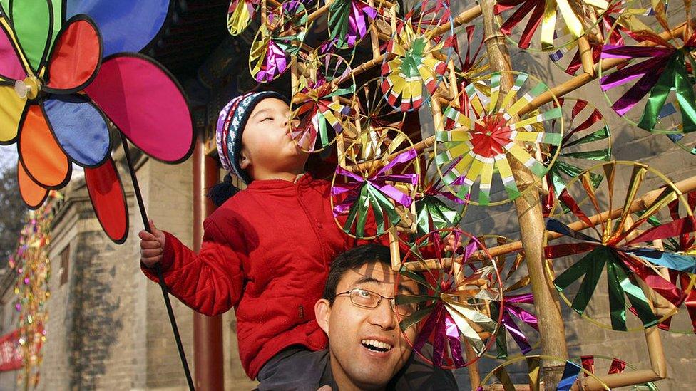 A child is carried on a man's shoulders as they blow handmade windmills on February 4, 2007 in Beijing, China. The Chinese Lunar New Year, or the Spring Festival, will fall on February 18.