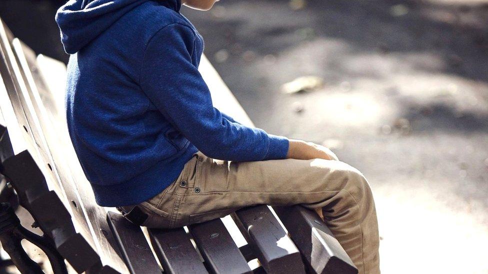 Stock photo of boy on park bench