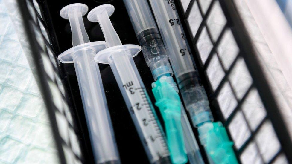 Four syringes in a plastic basket container