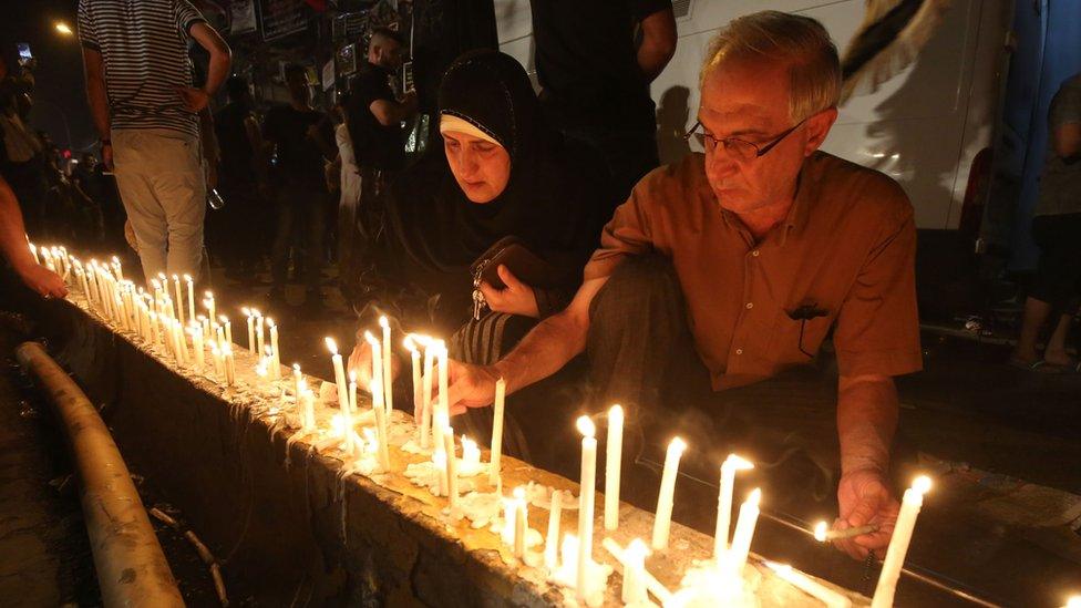 Iraqis light candles following Sunday's deadly suicide attack