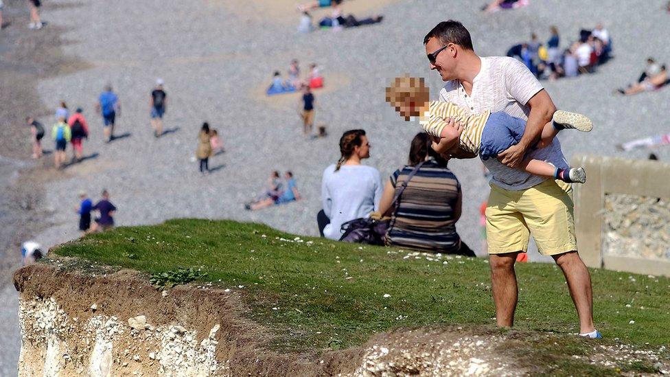 A man was spotted lifting a child o peer over the cliff edge at Seven Sisters