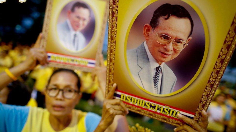 Well-wishers sing while holding up portraits of Thai King Bhumibol Adulyadej, during 88th birthday celebration at Siriraj Hospital in Bangkok on 5 December