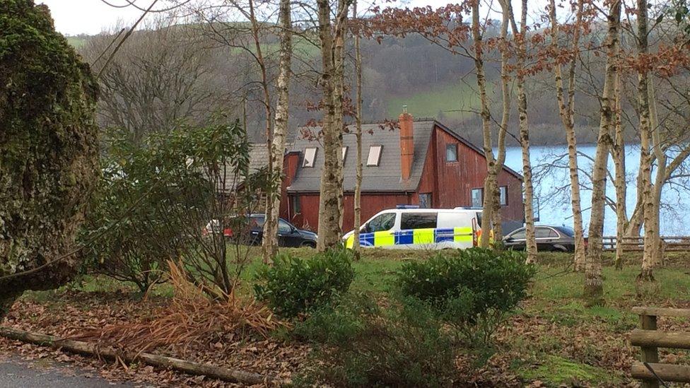 Police vehicle outside a house on the shores of Llyn Tegid