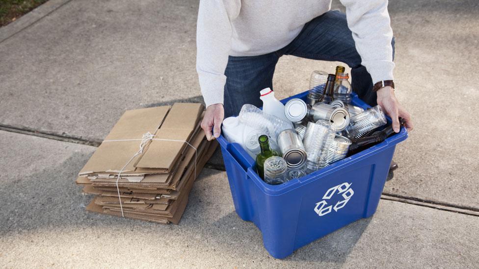 Recycling bin being picked up by householder