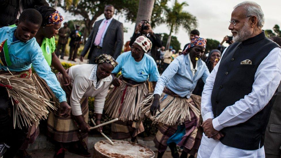 Indian Prime Minister Narendra Modi (R) looks at a band playing, as he arrives for a visit to the Centre for Innovation and Technological Development on 7 July 2016 in Maputo, Mozambique