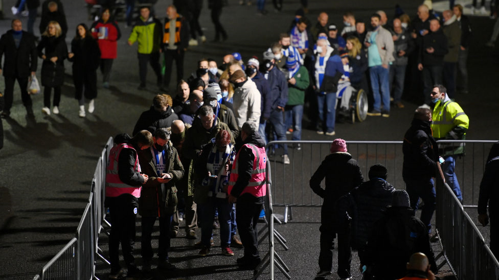 Football fans queuing to get into a stadium