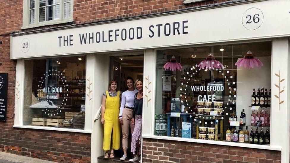 staff on doorstep of wholefood store