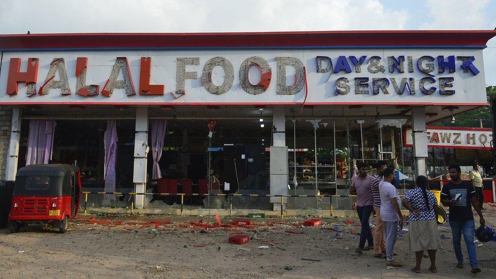 People gather outside a damaged shop after a mob attack in Minuwangoda on May 14, 2019, north of the Sri Lankan capital Colombo.