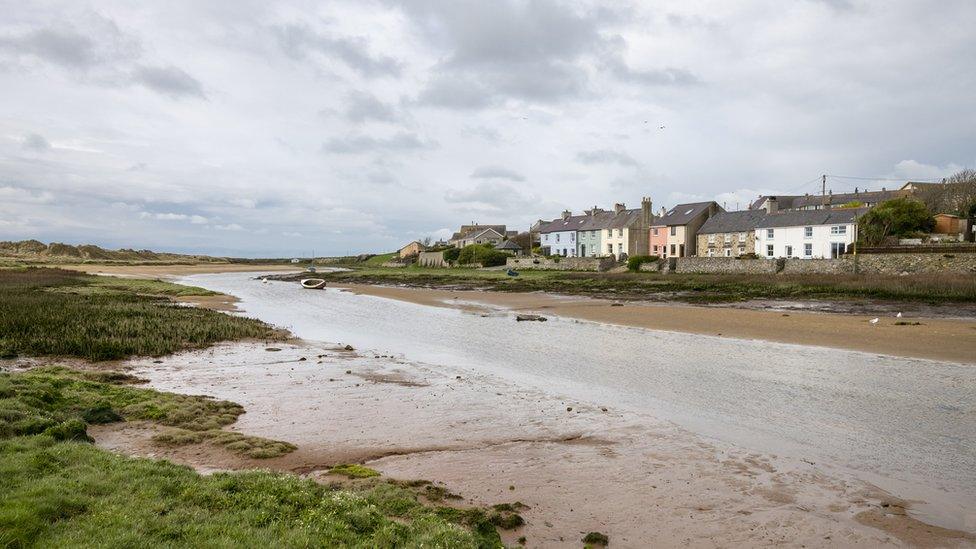 A village on the south west coast of Anglesey with houses beside the Afon Ffraw.