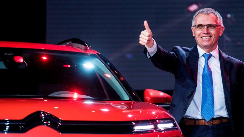 Carlos Tavares, CEO of PSA Peugeot Citroen, gives a thumbs up next to a CitroenC5 Aircross concept car during an event ahead of the 17th Shanghai International Automobile Industry Exhibition in Shanghai on April 18, 2017.