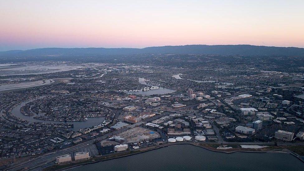 Aerial view of Silicon Valley at dusk, with a portion of the San Mateo/Hayward Bridge visible, as well as Foster City, including the California headquarters of Gilead Sciences, Visa, and Conversica, California, July, 2016.