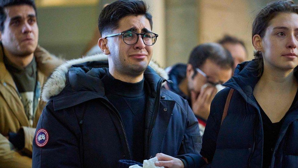 A man weeps during a service at Western University for four graduate students killed in the plane crash