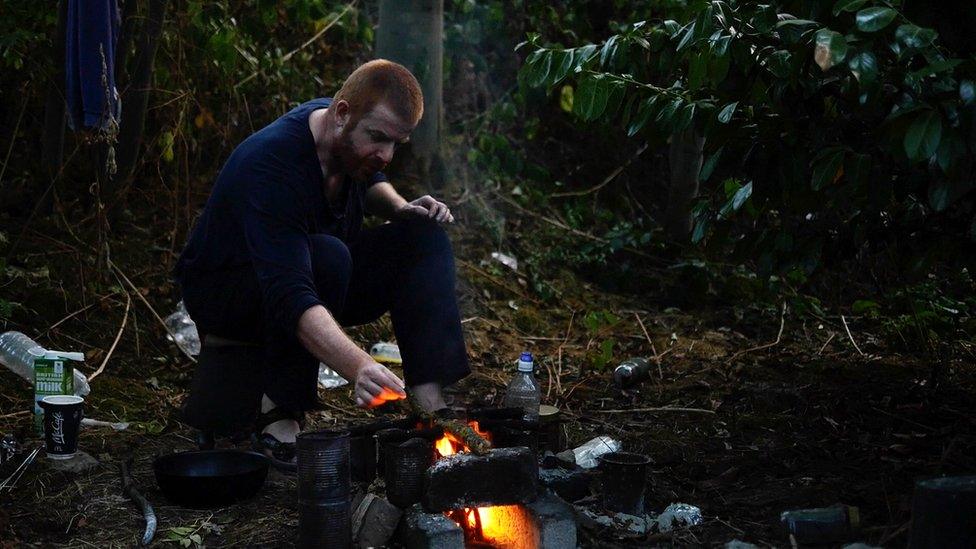 John O'Neill in a wood heating camp fire