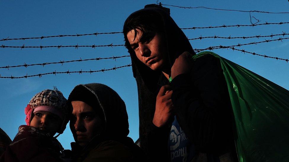 People wait to enter a migrant processing centre on the Greek island of Lesbos