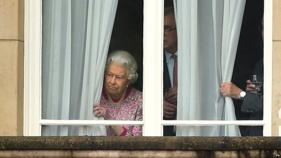 The Queen peers out of the window at Buckingham Palace