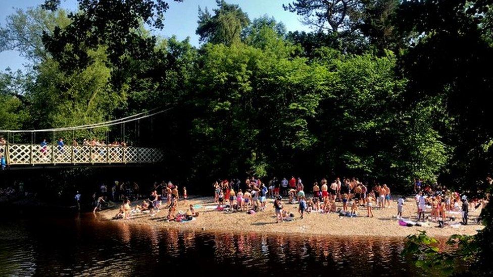 Lots of people on a riverbank in Ilkley