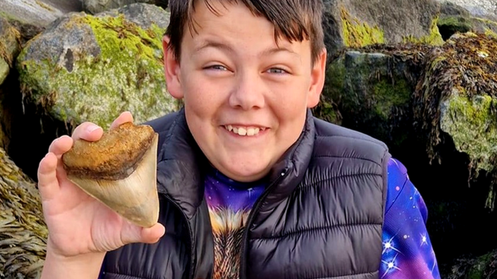 Ben with the 10cm-long tooth he found at Walton-on-the-Naze in Essex