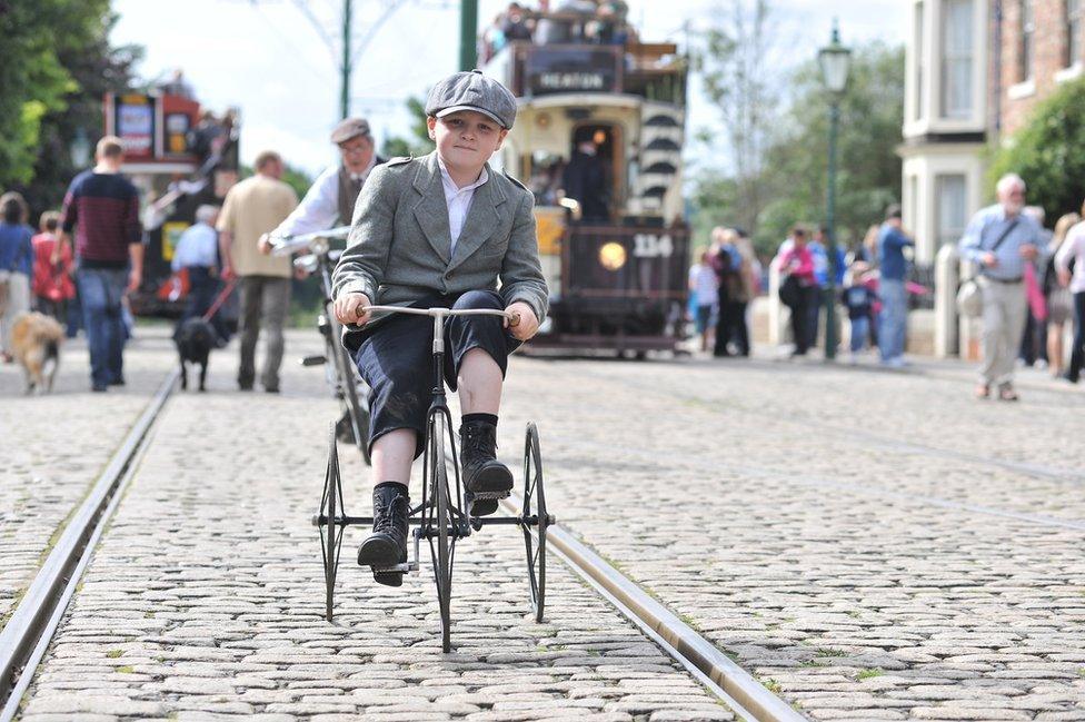 Child riding a 1930s tricycle