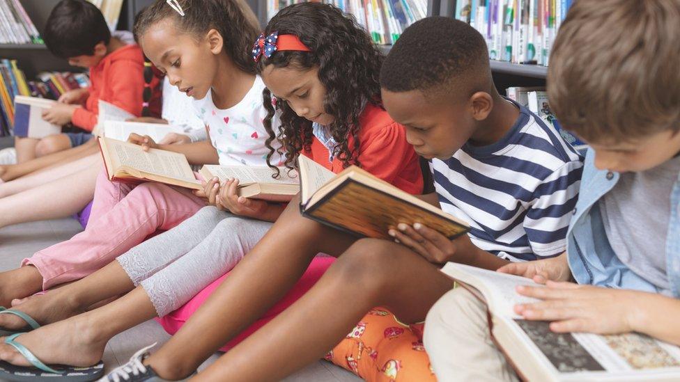 Children reading books in a library.