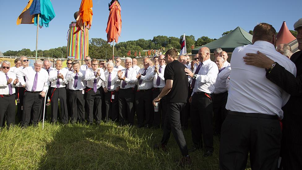 ôr Meibion y Penrhyn yn croesawu Damon Alban i gefn llwyfan yn 2019