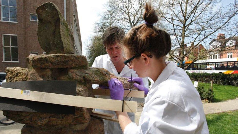 Staff restoring sculpture