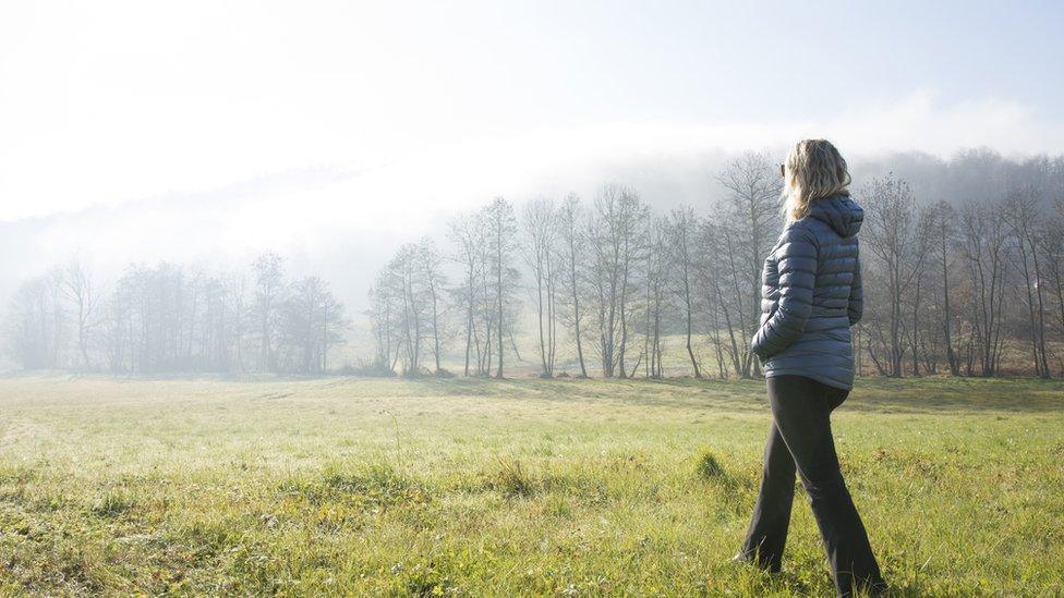 Woman walking across a field