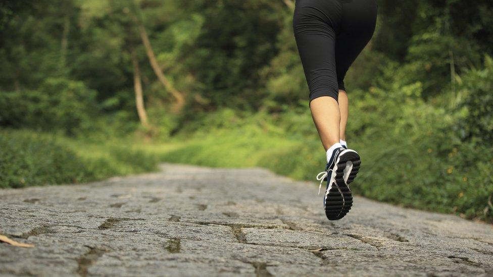 Woman running down country road