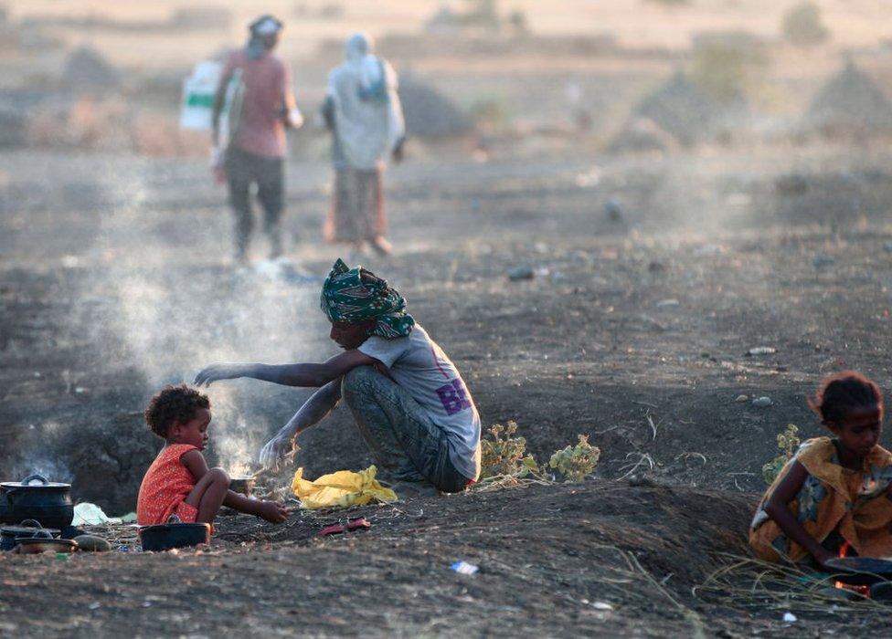 Ethiopian refugees who fled intense fighting in their homeland of Tigray, cook their meal in the border reception centre of Hamdiyet, in the eastern Sudanese state of Kasala, on November 14, 2020. - Ethiopia's Prime Minister Abiy Ahmed, winner of last year's Nobel Peace Prize, ordered military operations in Tigray last week, shocking the international community which fears the start of a long and bloody civil war.