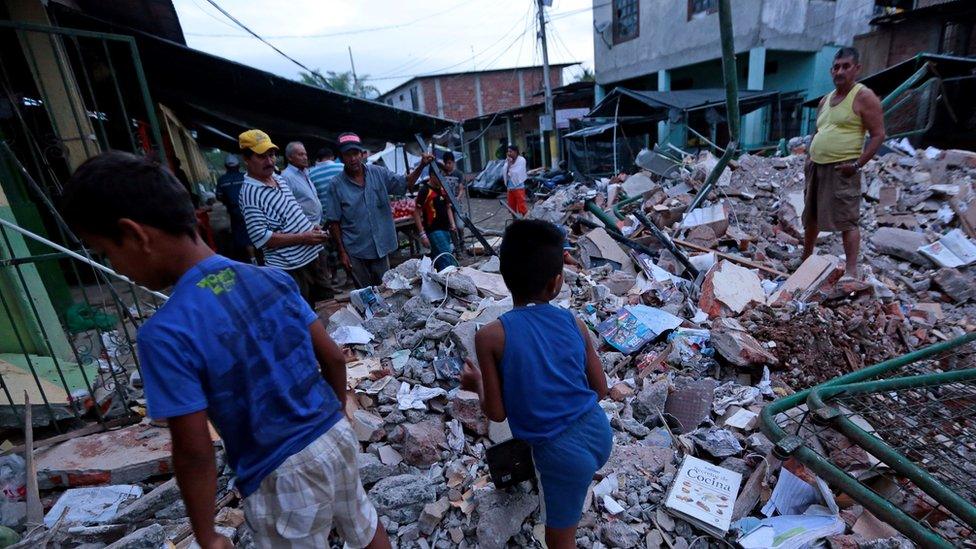 People look through rubble after a quake in Ecuador