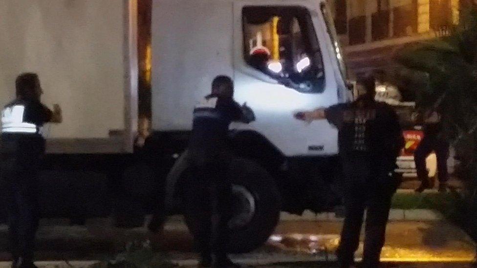 Police shine a light into the lorry's cab as they approach