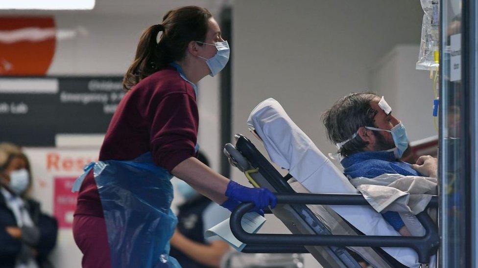 Hospital worker pushing a patient in a bed